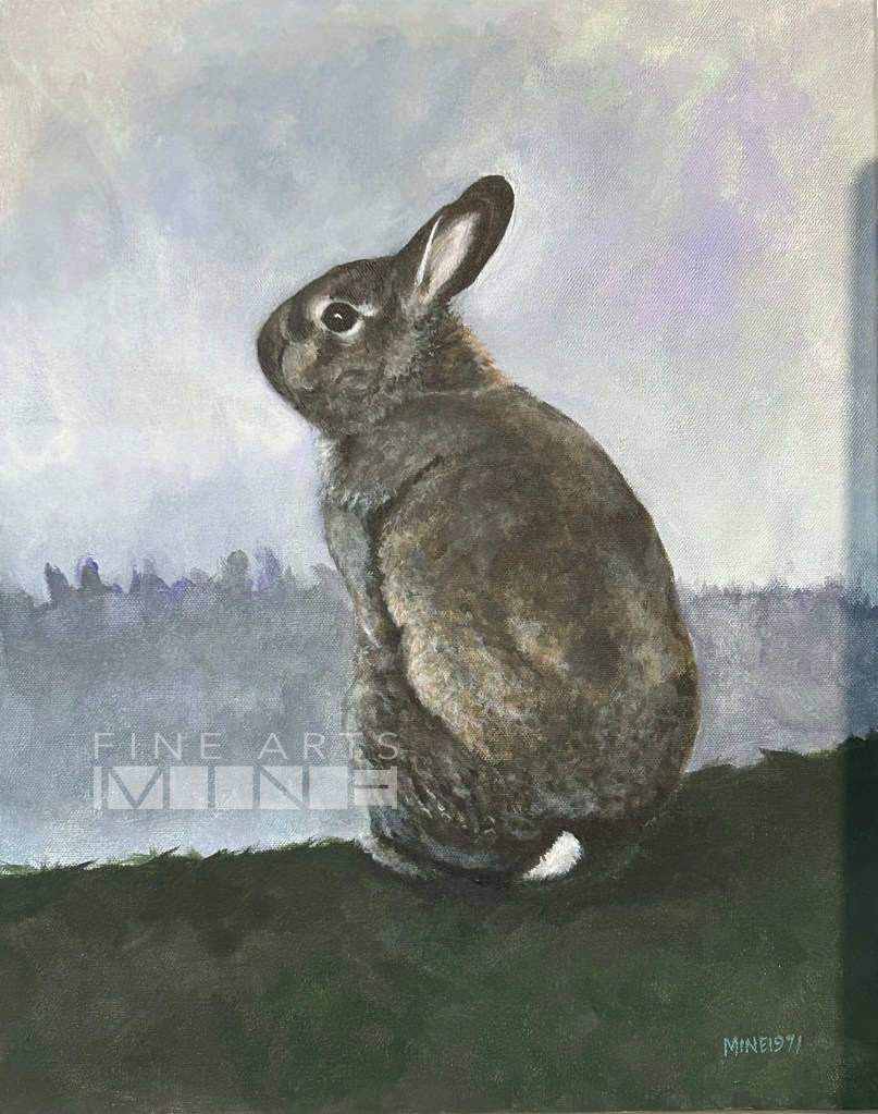 Charcoal grey rabbit overlooking a cloudy landscape.